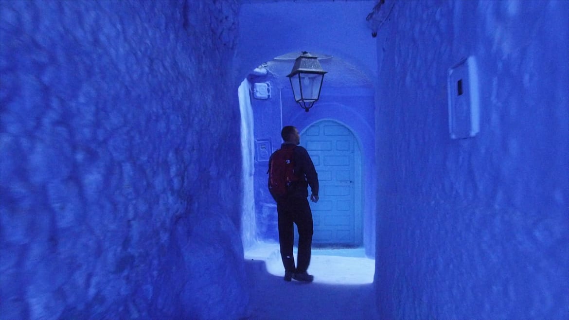 Homem caminha na incrível cidade azul de Marrocos, Chefchauen